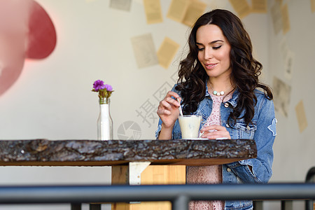 轻的女人坐室内喝咖啡20多岁的轻现代白种人女咖啡馆城市生活方式图片