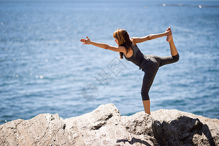 轻的女人海滩上瑜伽女穿着运动服装图片