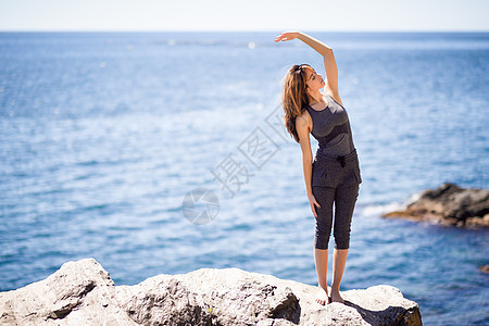 轻的女人海滩上瑜伽女穿着运动服装图片