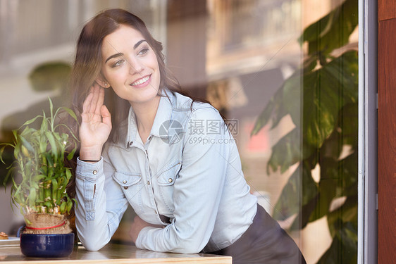咖啡馆城市生活方式轻的女人坐时髦的城市咖啡馆里,透过窗户看着酷的轻现代白种人女模特她20多岁图片
