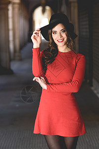 轻女的肖像,时尚模特,穿着红色连衣裙帽子城市背景上微笑图片