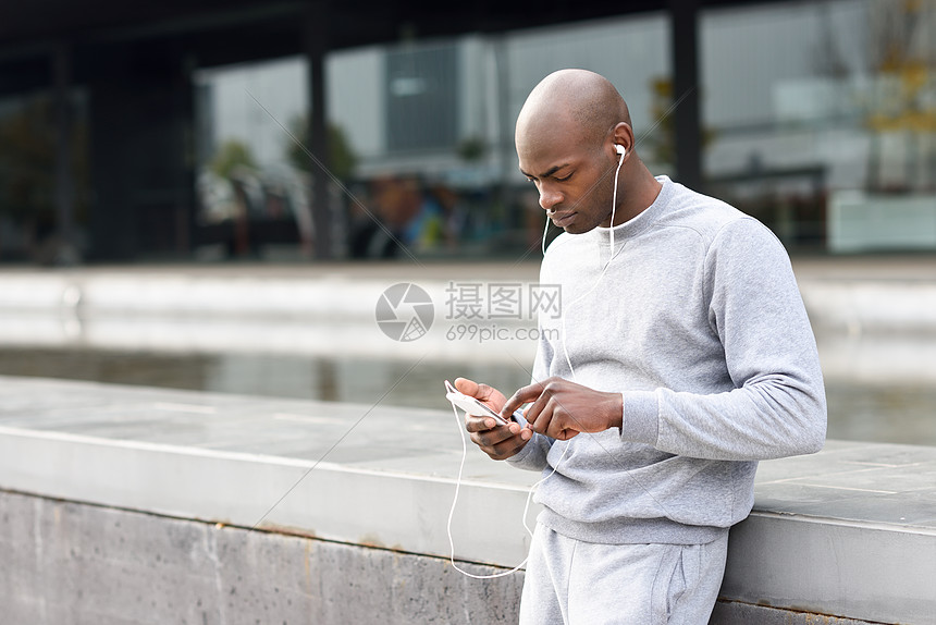 吸引力的黑人城市里用耳机听音乐吸引力的黑人城市背景下用耳机听音乐男户外运动服图片
