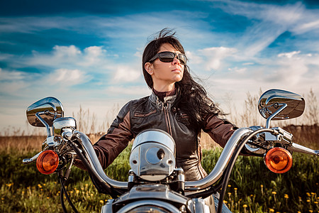 骑自行车的女孩穿着皮夹克太阳镜坐摩托车上图片