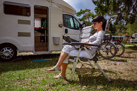 女人看着野营附近的笔记本电脑房车度假家庭度假旅行,度假旅行汽车房车无线连接信息通信技术图片