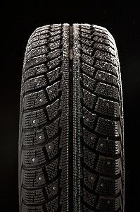 冬季轮胎覆盖黑色背景上的雪中轮胎盖图片
