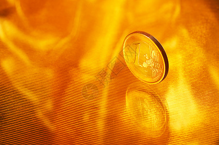 值1欧元的硬币反光的条纹黄金背景上的边缘上花费货币想象图片