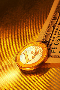 硬币值1欧元以上100美元额的条纹黄金背景反射货币想象图片