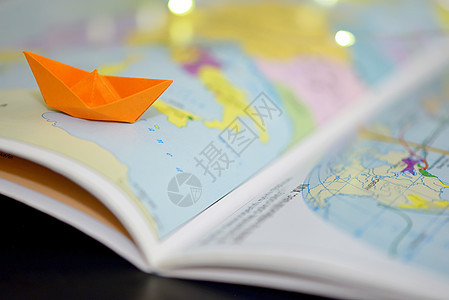 世界集书上的纸船背景图片