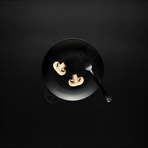 厨房用具的创意照片,黑色背景上画食物的盘子图片