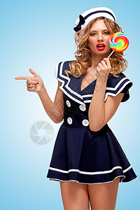 创造的照片,个好玩的钉来的水手女孩与个彩色棒棒糖,指边的蓝色背景上的手指图片