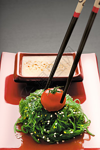 个筷子的特写,着个红熟的西红柿朱卡沙拉戈马达酱背景图片
