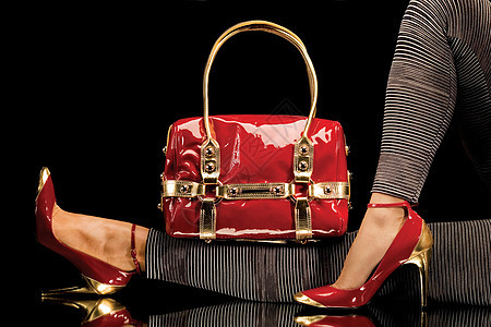 个别致的红色手提包的特写,还感的女腿,穿着优雅的红色鞋子图片