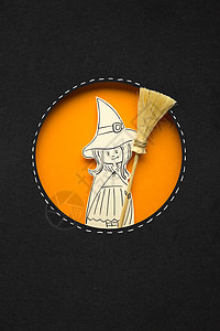 创意万节照片女巫与扫帚制成的纸张黑色橙色背景图片