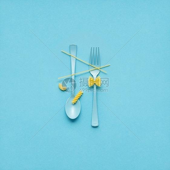 创意静物照片的叉子勺子与生意蓝色背景图片