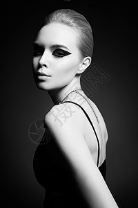 时尚工作室照片美丽时尚的女人与明亮的化妆黑色配件时尚箭头形状滚风格背景图片