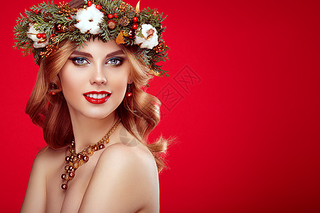 带诞花环的美丽轻女人的肖像美丽的新诞树假日发型化妆美女肖像孤立红色背景上五颜六色的妆容头发图片