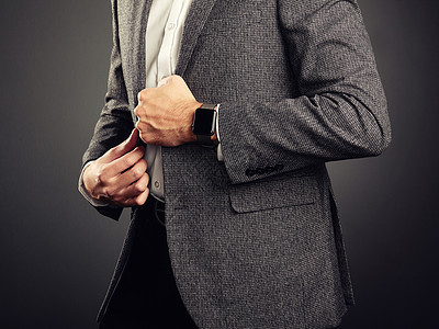 穿着西装的英俊轻人休闲风格电子设备智能手表,商业风格图片