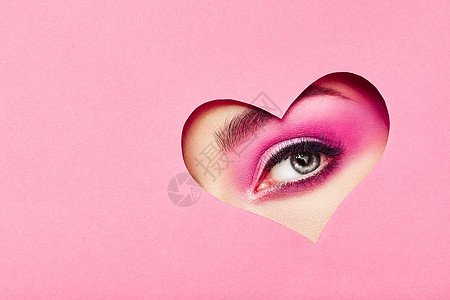 情人节照片带着节日粉红色妆容的女孩的眼睛粉红色背景上的纸心爱的象征情人节图片
