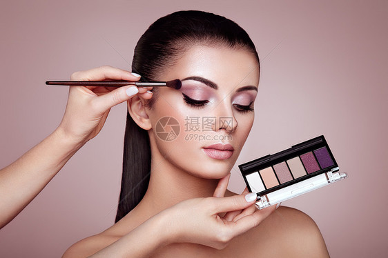 化妆师应用眼影化妆师应用眼影漂亮的女人脸完美的妆容化妆细节美丽的女孩完美的皮肤指甲指甲眼影调色板图片