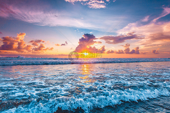 日落海洋上美丽的日落天空背景前溅海浪图片