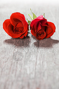 心形玫瑰两朵心形的红色玫瑰木制背景上,情人节图片