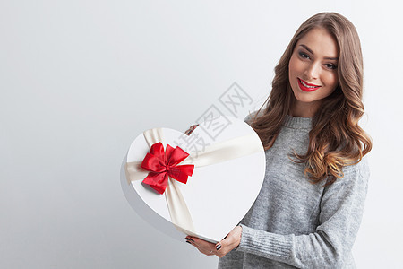 红色心形盒子的女孩白色背景上红色心形礼品盒的轻女孩图片