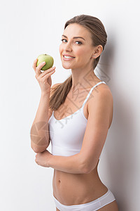 带苹果的运动女人轻迷人的运动女人穿着白色内衣着绿色的苹果图片