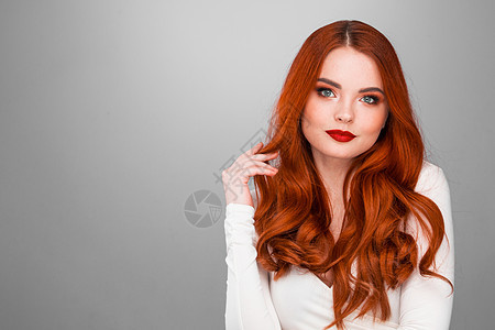 漂亮的红头发女孩华丽的红头发女孩波浪发型美容工作室肖像图片