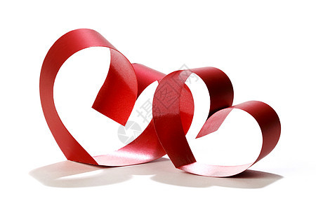 两颗相连的红丝带的心被隔离白色的背景上图片
