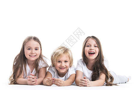 快乐的孩子白色上被隔离快乐的微笑三个穿着白色衣服的孩子躺白色背景上地板上图片