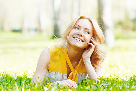 快乐的轻女人躺绿色的草地上草地上的轻女人图片