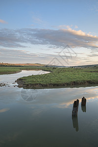 美丽的日出景观英国乡村,河流慢慢流过田野图片
