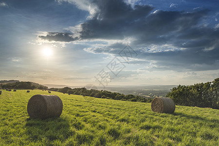 美丽的夏季日落乡村的田野景观与干草捆图片