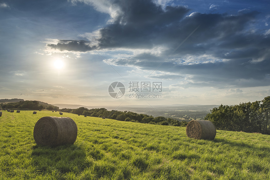 美丽的夏季日落乡村的田野景观与干草捆图片