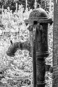 老式旧生锈水泵废弃的花园老式老锈水泵废弃的花园黑白图片