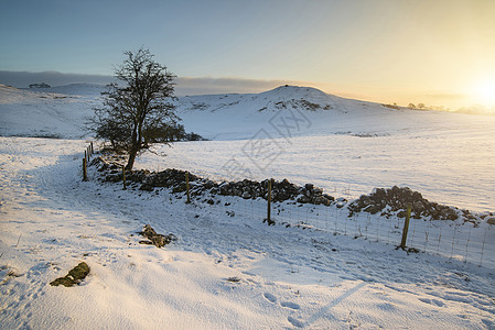 山顶日出时,美丽的雪覆盖了冬季的景观风景雪覆盖了英格兰高峰地区日出时的冬季景观背景图片