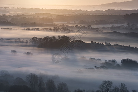 令人惊叹的雾状英国乡村景观日出冬季美丽的雾状英国乡村景观日出冬天,层层滚动田野背景