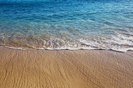 波浪海滩上的蓝色波浪模糊背景阳光斑点平的自然背景图片