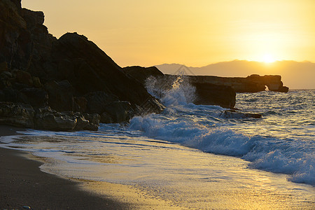 海浪溅岸边的石头上图片