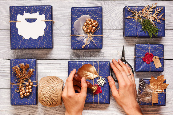 女人包装诞礼物创造地包装装饰诞礼物盒子上的木制背景顶部的视图平躺图片