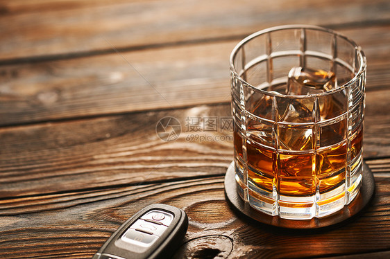 杯威士忌酒精饮料,加冰块汽车钥匙,放乡村木桌上,喝酒开车酗酒的安全负责的驾驶理念图片