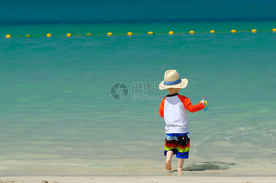 两岁的蹒跚学步的男孩海滩上玩海滩玩具图片