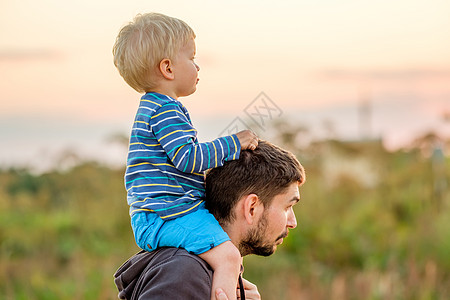 快乐的男人他的孩子户外玩得很开心家庭生活方式农村场景的父亲儿子夕阳的阳光下图片