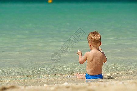 海滩上的蹒跚学步的男孩两岁的蹒跚学步的男孩海滩上图片