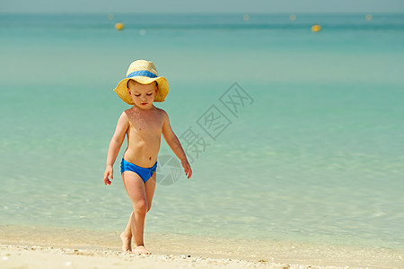 两岁的蹒跚学步的孩子海滩上玩耍两岁的蹒跚学步的男孩海滩上玩耍图片