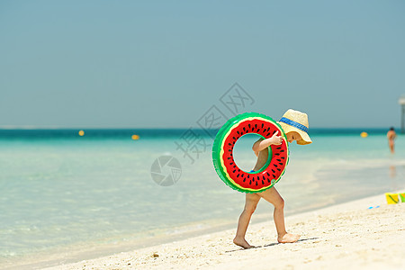 海滩上戴着游泳环的蹒跚学步的男孩两岁的蹒跚学步的男孩,海滩上充气游泳圈图片