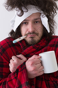 轻人流感发烧包裹着杯愈合的茶,隔离白色的图片