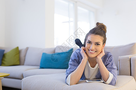 轻快乐的女人豪华的家里用手机沙发上图片