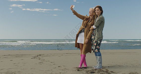 朋友自拍两个美丽的轻女人秋天的海滩上自拍图片