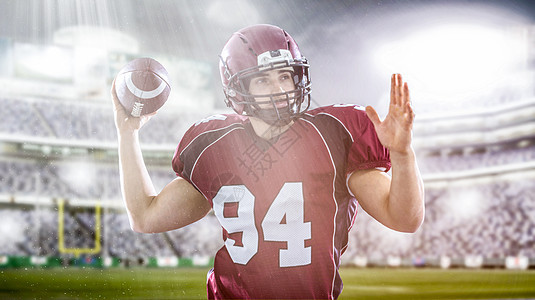名四分卫美国足球运动员用灯光照明弹大型现代体育场投掷球背景图片